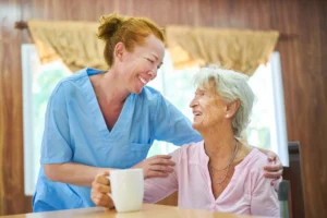 Fürsorgliche Pflegekraft oder Altenpflegerin kümmert sich um Seniorin im Pflegeheim oder zu Hause