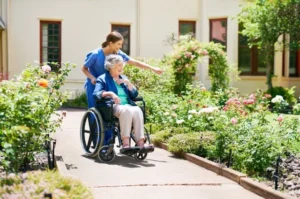 Eine Pflegekraft und ein Bewohner freuen sich im Garten eines Altenheims. Die Aufnahme symbolisiert Menschlichkeit und Fürsorge im Pflegealltag – passend zur Meldung über den steigenden Pflege-Mindestlohn ab dem 1. Juli 2025.
